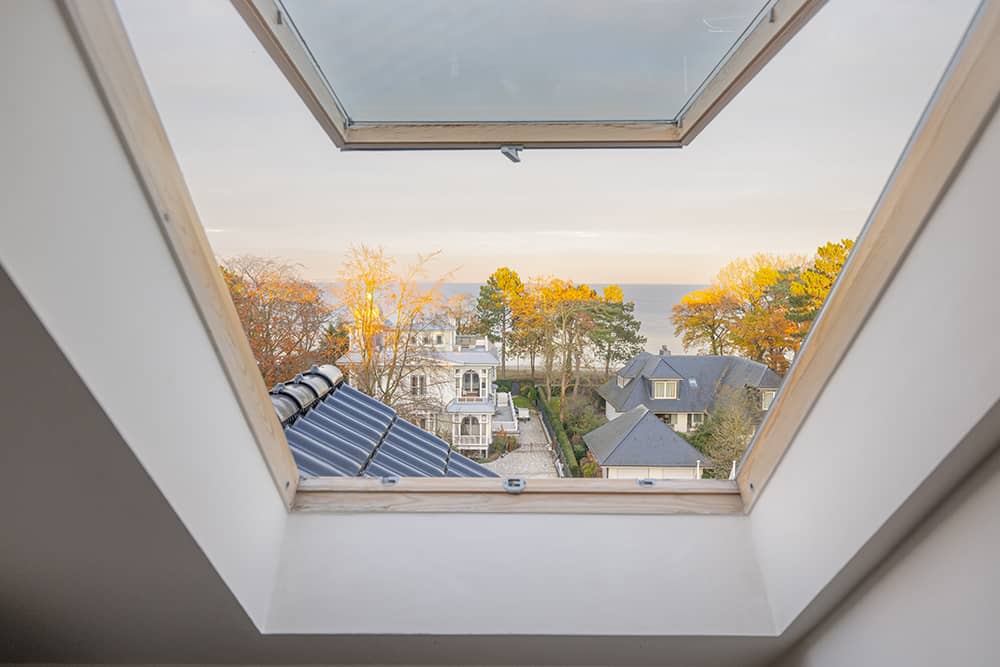Blick Richtung Ostsee durch ein geöffnetes Dachschrägenfenster.